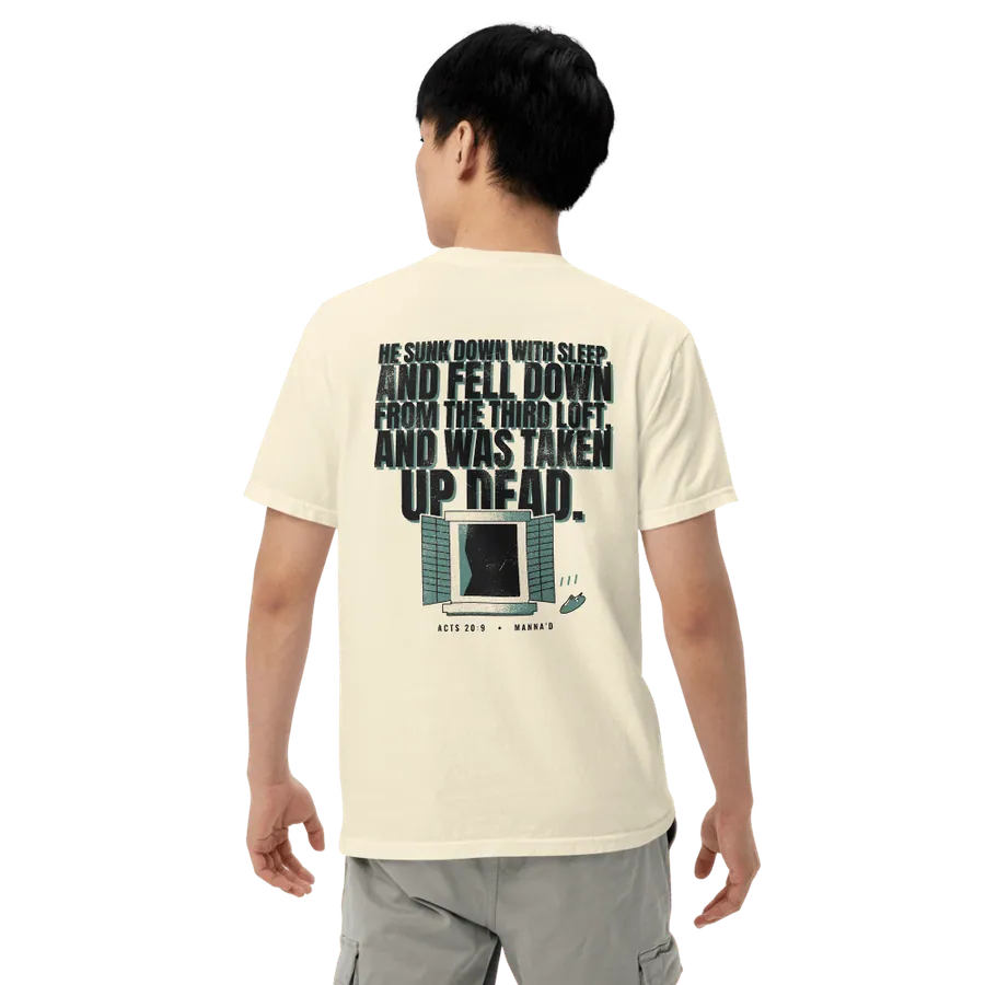 Model wearing the bone Manna’d tee, back printed HE SUNK DOWN WITH SLEEP, AND FELL DOWN FROM THE THIRD LOFT, AND WAS TAKEN UP DEAD. (Acts 20:9)